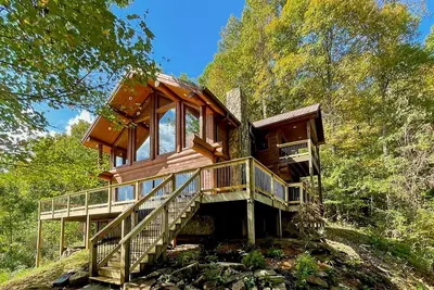 Image de Secluded log cabin with fireplace and hot tub on deck.