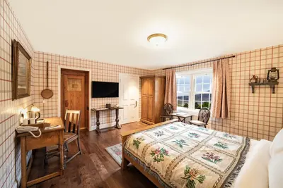 Image de The wooden floors, vintage furniture, and tartan accents create a comfy room