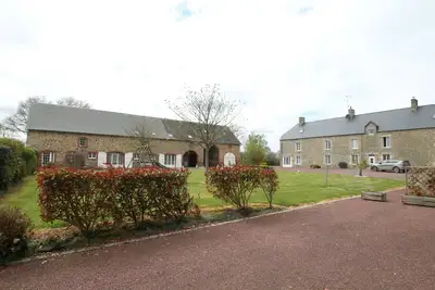 Maison familiale avec piscine intérieure chauffée, espace jeux, et terrasse dans corps de ferme rénové