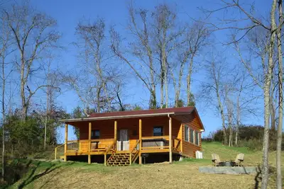 A cozy new cabin in rural setting with a hot tub on porch. Beautiful rural view.