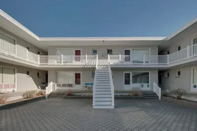 Image de located in the heart of Stone Harbor just 3 blocks from downtown 96th Street shopping area and 1 1/2 blocks to the beach. The courtyard is furnished with outdoor table, chairs and umbrellas.