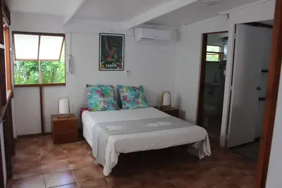 Image de Bungalow dans jardin partagé avec une maison, bord de mer, et sa plage privée.