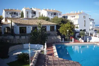 Image de Appartement de luxe avec vue sur les montagnes et la mer, piscine et balcon partagés.