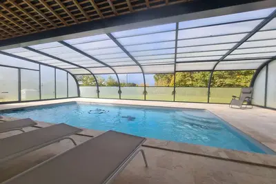 Image de Maison isolée avec jardin, piscine intérieure chauffée et équipements pour des vacances de rêve.