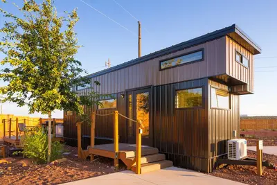Image de modern tiny home with a hot tub and bbq