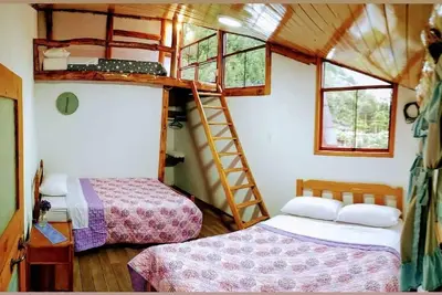 Image de Habitacion tipo cabaña con acabados en madera, terraza con vista hacia la montaña