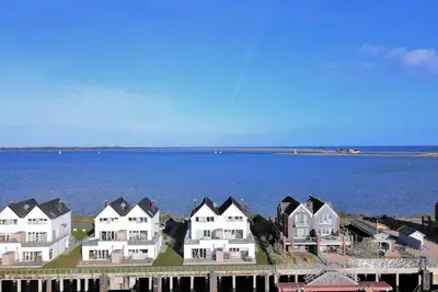 Image de Appartement 'Brigantine 33 By Seeblick Ferien' avec vue sur la mer et terrasse privée.