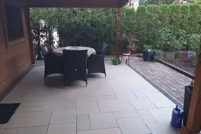Image de Un appartement de 2 chambres avec terrasse couverte dans le jardin.