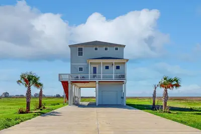 Brand new coastal gem with bay/wetland views, two balconies, & outdoor shower