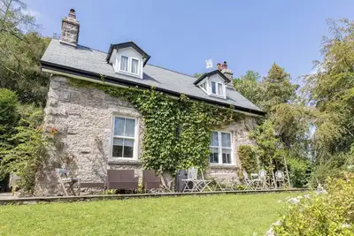 A detached property with amazing views to the coast, a private hot tub and beautiful gardens.