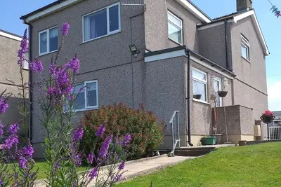 Image de An immaculate spacious house with pretty garden, off road parking and sea views in the distance.