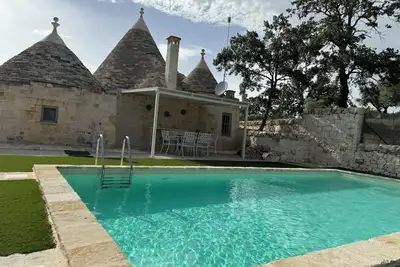 Aprus trullo surrounded by greenery with private pool.