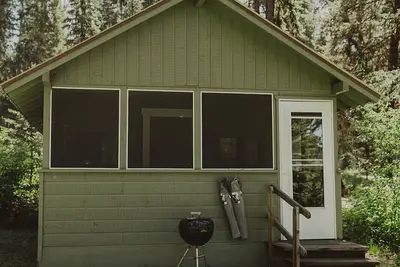 Image de Huckleberry Cabin at Tamaracks Resort with a lake facing furnished screen porch.