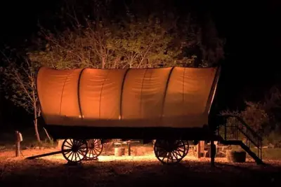 Image de Cozy Wild West Covered Wagon next to River