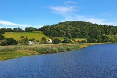 A secluded riverside cottage nestled in the Devon countryside.