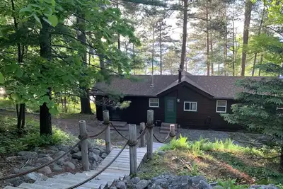Image de Cabin Nestled Amongst Towering Pines Bluff Overlooking \nMain Body of Woman Lake