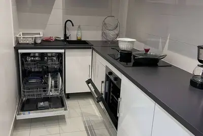 Image de L'appartement dispose d'un lit, d'un canapé-lit et d'une cuisine avec un réfrigérateur