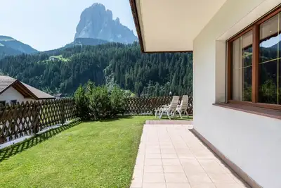 Image de Appartement 'Hotel Residence Gardena Alps 100' avec vue sur les montagnes, jardin et Wi-Fi.