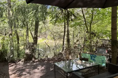 Image de Bungalow 'im Wald am See - Biberspur' avec vue sur le lac et jardin.