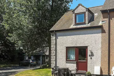 Image de This silver cottage features an open kitchen, dining room, and living room.