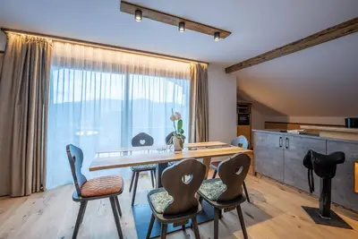 Image de Appartement 'Ladinser Hof Western Suite' avec vue sur les montagnes et balcon.