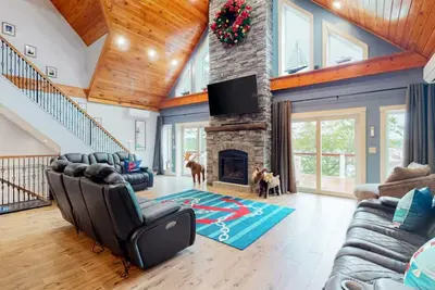 Image de Luxurious waterfront home with deck, firepit, hot tub, fireplace, & pool table