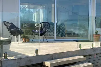 Image de Beachfront stunning modern sunny split level home. Outside hot bath.