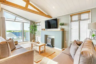 Image de New for 2022. Luxurious lodge with vaulted ceilings and a welcoming feature fireplace.