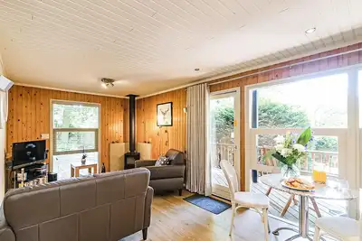Stylish open plan lodge with king-size four poster bed.