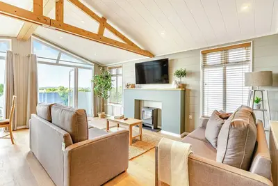 Image de New for 2022. Luxurious lodge with vaulted ceilings and a welcoming feature fireplace.