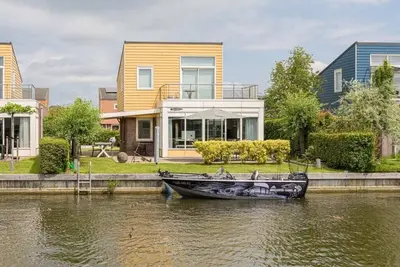 Image de Belle maison de vacances avec terrasse sur le toit et vue sur l'eau.