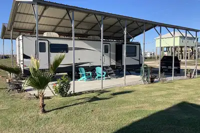 Image de 10 minutes walk to the beach. Covered rv spot on concrete slab. New Camper