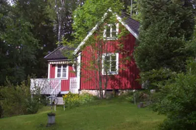 Image de Red and white cottage with a boat not far from the lake