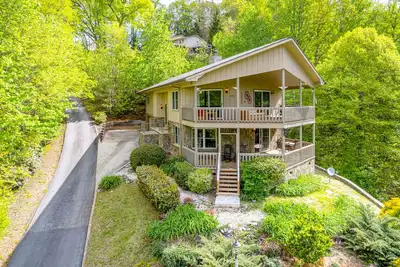Image de View-worthy home lined by trees with a fireplace, wrap-around deck, grill, & W/D