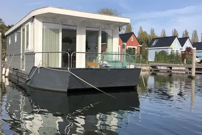 Image de Modern houseboat in quiet harbor close to the IJsselmeer with SUPs and canoe