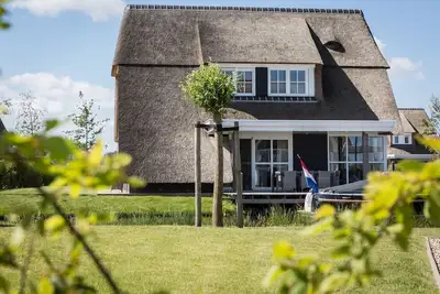 Image de Villa au toit de chaume avec salon sur l'eau