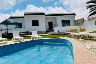 villa with pool front of beach