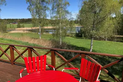 Image de Nice red-white cottage by the lake with a boat