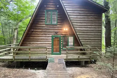 Image de A-frame cabin nestled in forest, stunning lake view, perfect serenity.