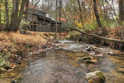 Image de Indulge in \"Just One More Night\", a pet-friendly creekfront retreat boasting a spacious outdoor deck, hot tub, firepit, and WiFi