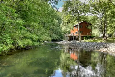 Image de Creeksong serenades with an expansive deck over-hanging Mountaintown Creek, perks include a hot tub, firepit, fishing and WiF