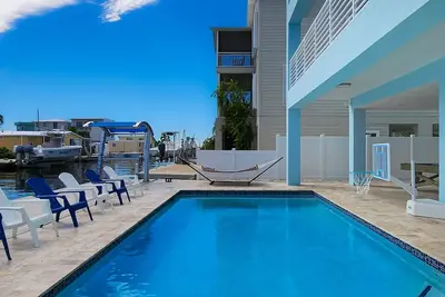 Image de Sprawling waterfront home with pool, outdoor kitchen, game table, grill, & W/D
