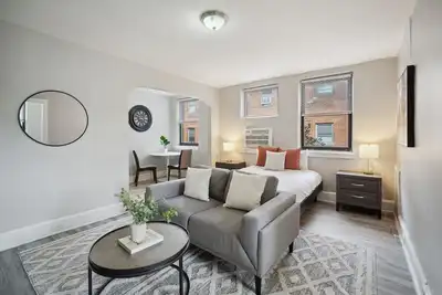 Image de This is a studio apartment with a separate kitchen nook, and a small living nook with a loveseat